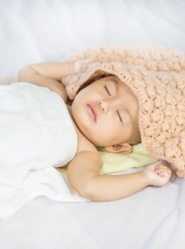 Baby sleeping on bed in the bedroom at home