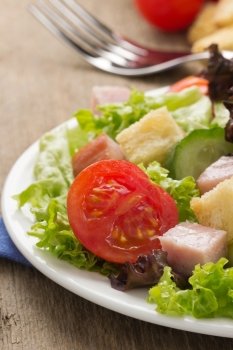 salad and fresh vegetables on wood background