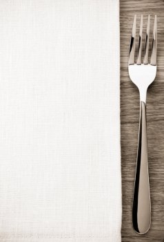 fork and napkin on wooden background