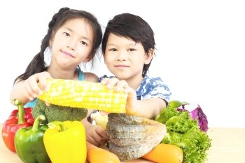 Asian boy and girl showing enjoy expression with fresh colorful vegetables isolated over white background