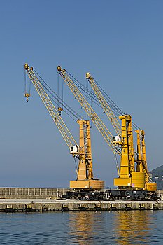 Crane at the port. View of three cranes in a commerciial harbor