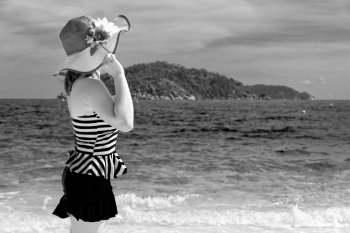 Black and white photograph for background, tourist girl in swimsuit standing with happiness on the beach and sea at Koh Miang Island, Mu Ko Similan National Park, Phang Nga province, Thailand