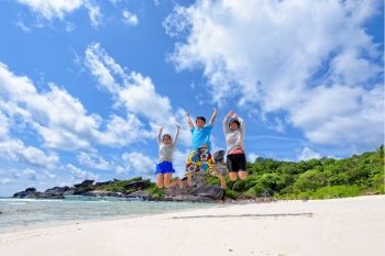 Family travels on vacation jumping with happy on beach near the sea under blue sky and clouds of summer at Koh Similan Island in Mu Ko Similan National Park, Phang Nga province, Thailand