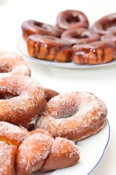 Sweet donuts on the plate with sugar and chocolate glaze.
