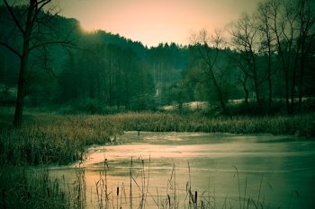 Creapy and haunted dark forest and lake at winter season.