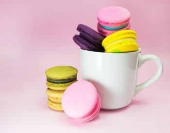 macarons in cup on pink background