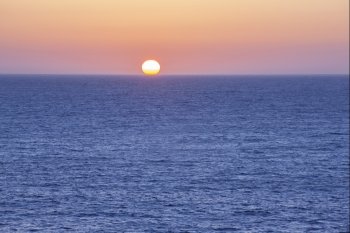 The sun setting in the ocean