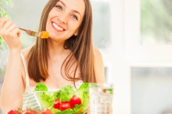 Photo of smiling caucasian woman eating salad 