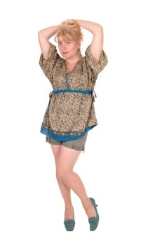 A middle age blond woman standing in shorts from the front, with her hands on her head, isolated for white background.