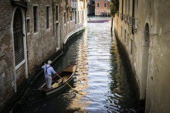 Man on a boat in Venice. Pass thru the channel
