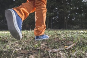 Child walking in the forest. Close up shoes