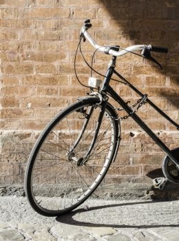 Old Italian bicycle on sunlight. Ancient buildings