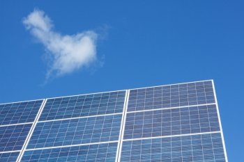 Solar panels and clouds against blue sky