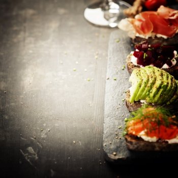 Tasty rye bread sandwiches with salmon, avocado, beetroot, creamcheese, ham, herbs and spices