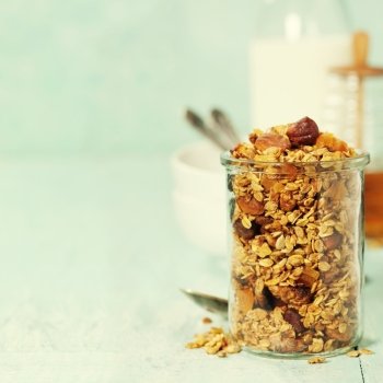 Homemade granola on rustic table. Healthy breakfast of oatmeal, muesli, nuts, seeds and dried fruit.