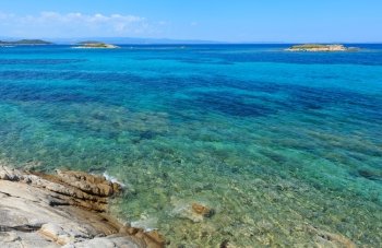 Aegean sea coast landscape with rocky island, view near Karidi beach (Chalkidiki, Greece).