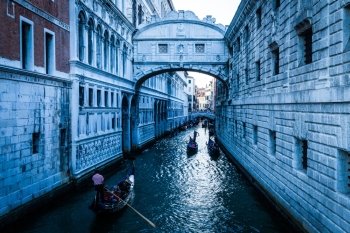 Tourists in gondolas sailing on the Rio de Palazzo o de Canonica Canal under the Bridge of Sighs (Ponte dei Sospiri) in Venice, Italy.