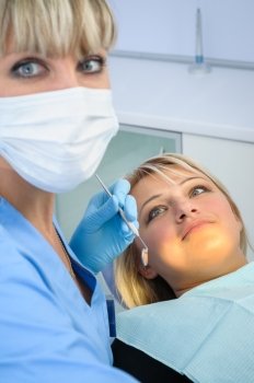 dentist at work with patient, after exam, cleaning, curing etc. Selective focus on patient face.