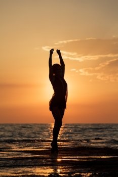 Dance at sunset. Silhouette of a girl dancing on the background of sea sunset
