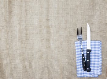 Canvas tablecloth, fork, knife for steaks and napkin. Is used to create a menu for a steak house. The background for the menu.