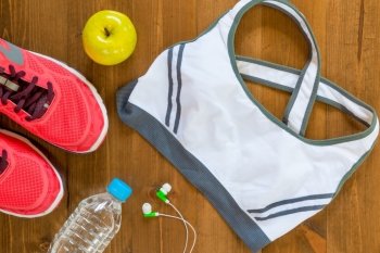sports bra and sneakers for fitness a top view of the wooden floor