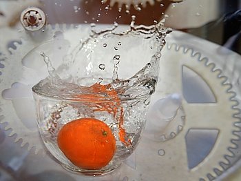 orange fruit  is falling and splashing into water incolor .   Concept of time
