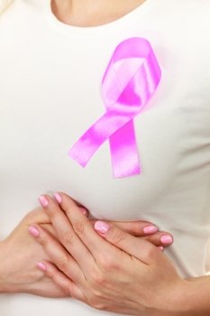 Healthcare, medicine and breast cancer awareness concept. Closeup pink cancer ribbon on woman chest