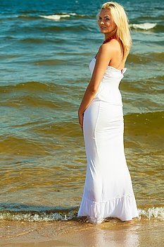 Woman in dress on coast. . Woman in dress on coast. Young lady posing on beach. Outdoor relax leisure concept. 