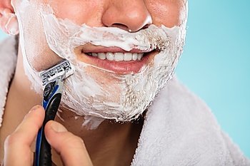Man shaving using razor with cream foam.. Man shaving using razor with cream foam. Guy removing face beard hair. Skin care and hygiene.