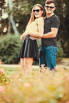 Couple hugging in park. . Love romance relationship dating leisure concept. Couple hugging in park. Young girlfriend with her man together holding hands. 