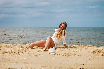 Happy woman on summer beach.. Happiness and craziness. Smiling crazy girl have fun outdoor. Young attractive long haired woman playing on summer beach.