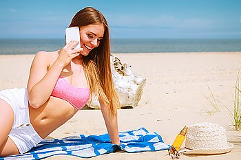 Woman on beach talking by mobile phone.. Technology and communication. Happy smiling woman with mobile phone calling to people friends. Young attractive girl talking by smartphone on beach.
