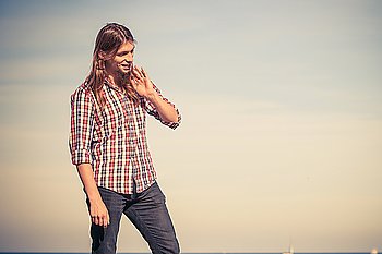 Man long hair relaxing outdoor sky background. Man long hair wearing plaid shirt relaxing outdoor at sunny windy day against blue sky 