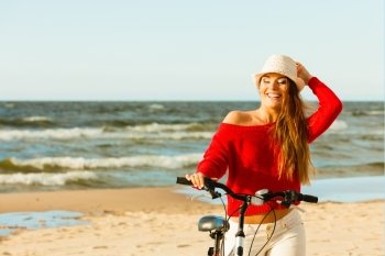 Fashionable girl with bike outdoor.. Young active girl with bicycle on seaside. Smiling cute woman resting near to sea in summer. Fashionable tourist on fresh air.