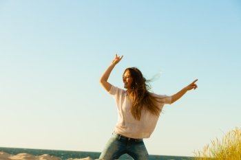Young joyful girl on beach.. Joy and carefree. Gorgeous long haired woman having fun on beach. Young joyful attractive girl feels freedom. Summer time.