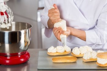 Chef pastry cream filling some biscuits