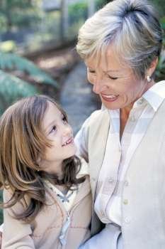 Close-up of a grandmother and her granddaughter smiling