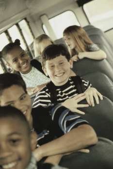Portrait of school children sitting in a school bus