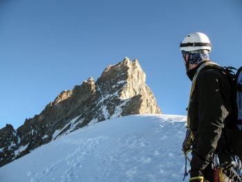 mountain guide looks ahead towards the climbing route and summit of a mountaineering tour in the Swiss Alps