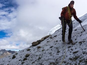 mountain climber on a steep rock and snow slope in the Andes of Peru