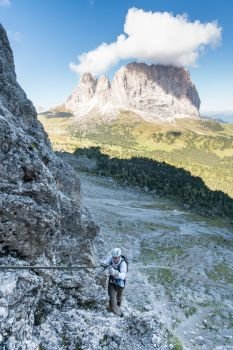 young attractive male mountain climber in the Dolomites of italy with a great panorama view