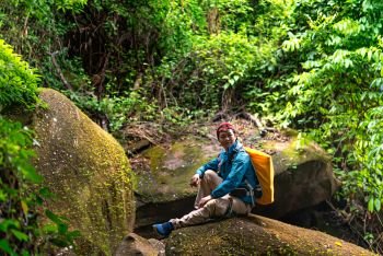 photo of asian backpacker travel in rainforest. backpacker travel in rainforest