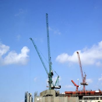 photo of working crane against blue sky
