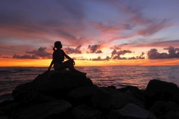 silhouette of women sitting on the beach beautiful sky background
