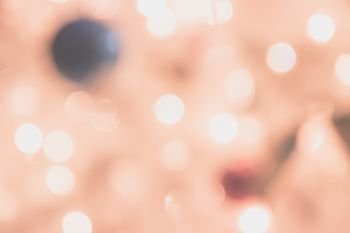 Defocused bokeh light background with decoration for Christmas and New Year Celebration (Pink and Orange tone)