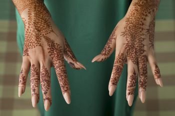 Moroccan woman showing the upside of traditional henna painted hands 