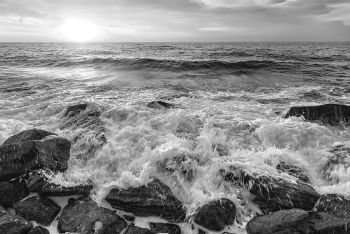 The stunning black and white seascape with the sky and water foam at the rocky coastline of the Black Sea