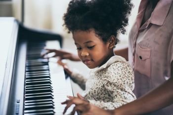 Mother is teaching piano tricks, African people