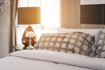 morning scene of modern bedroom with pattern pillows and lamp