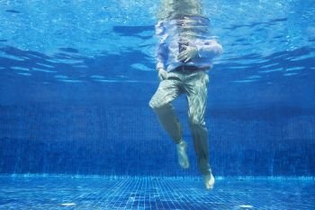 Low angle of businessman's legs underwater